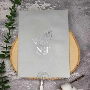 کارت عروسی کد M276 با پاکت طوسی با گل نقره‌کوب و لایی کشویی از پایین، رنگ طوسی و لایی طلقی با منگوله آویز